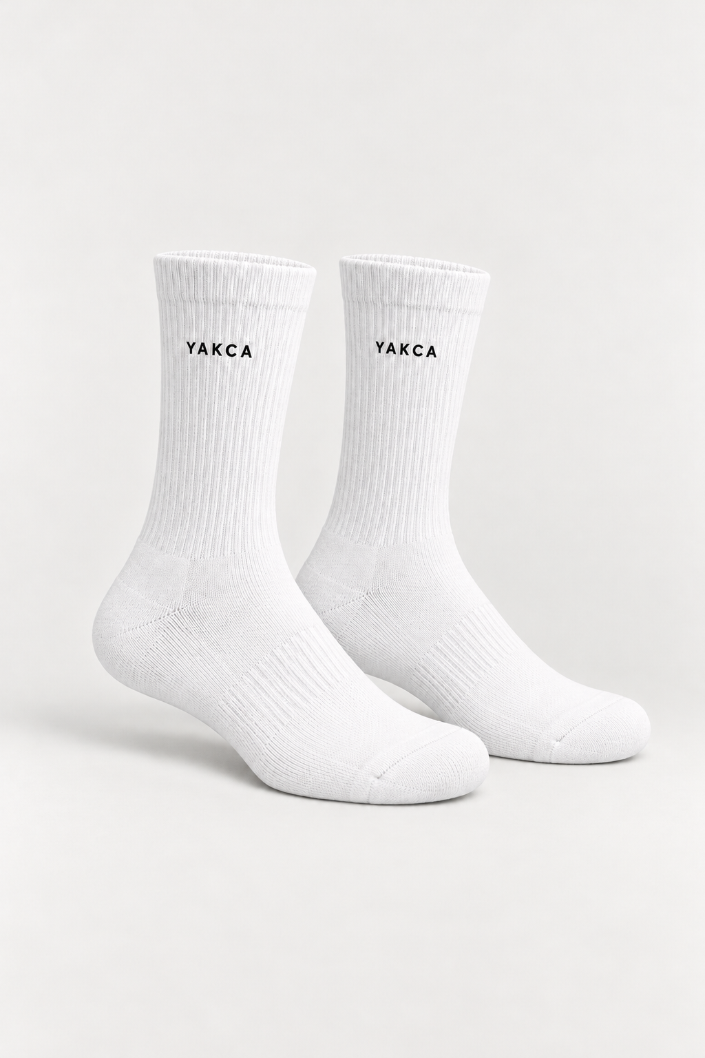 YAKCA CORE white ribbed crew socks with small dark YAKCA logos, one pair
